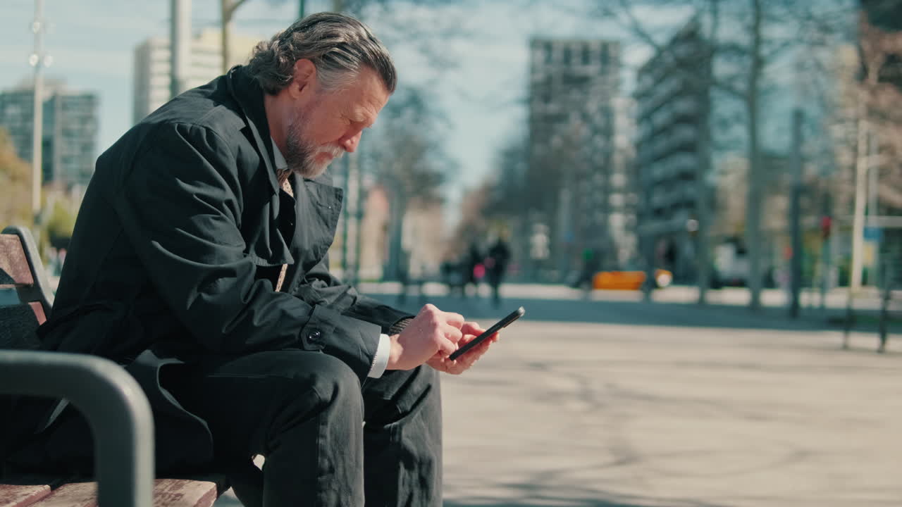 Businessman Using Smartphone On Bench