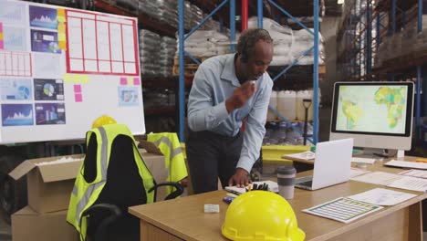 man working at a desk in a warehouse 4k