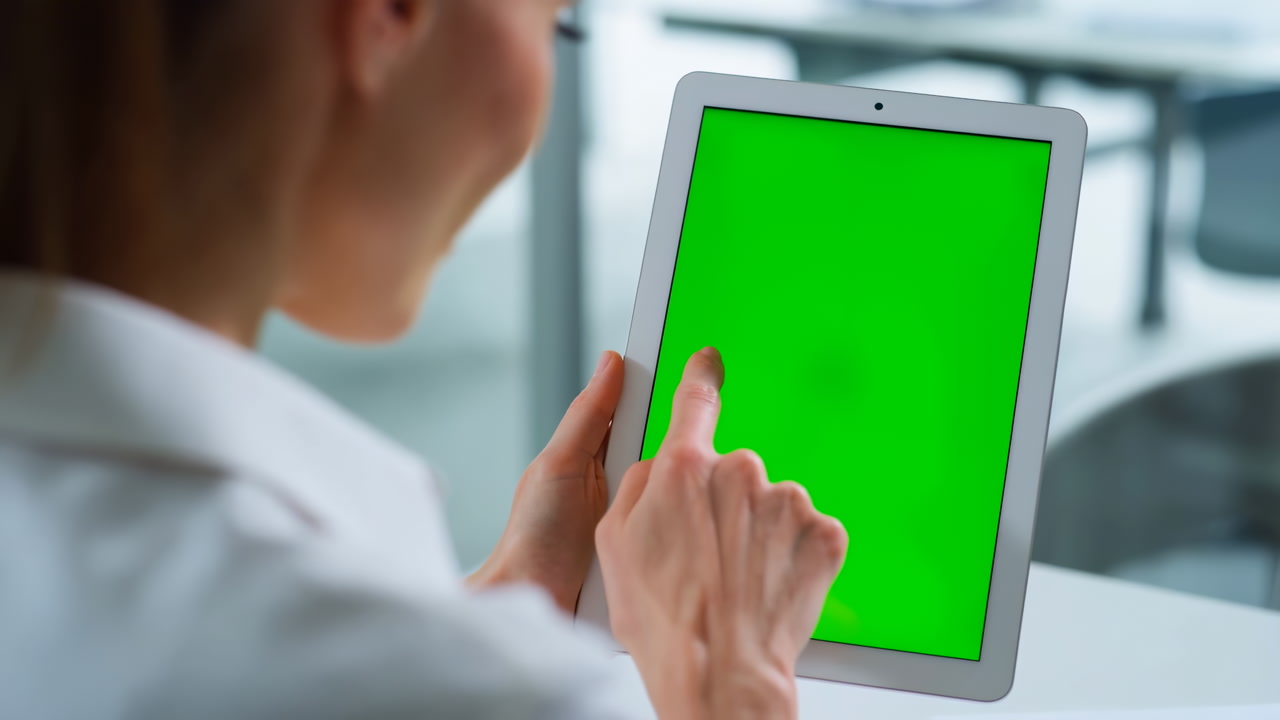 Woman Holding Tablet Green Screen, Tapping Interface In Bright Clinic Setting, Wearing White Coat,