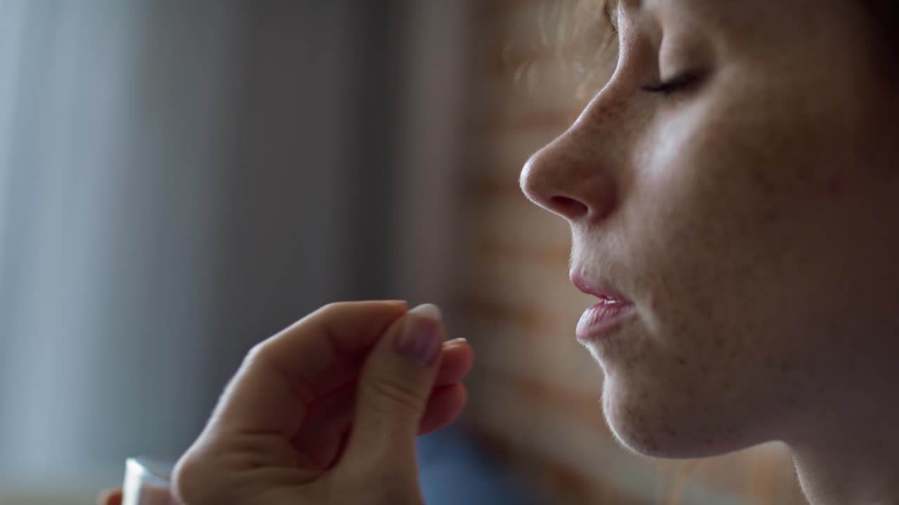 Donna rossa caucasica che sta per prendere delle pillole e bere acqua.