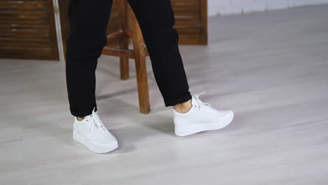 fashionable white comfortable shoes presentation. lady demonstrating beautiful footwear walking in the studio.