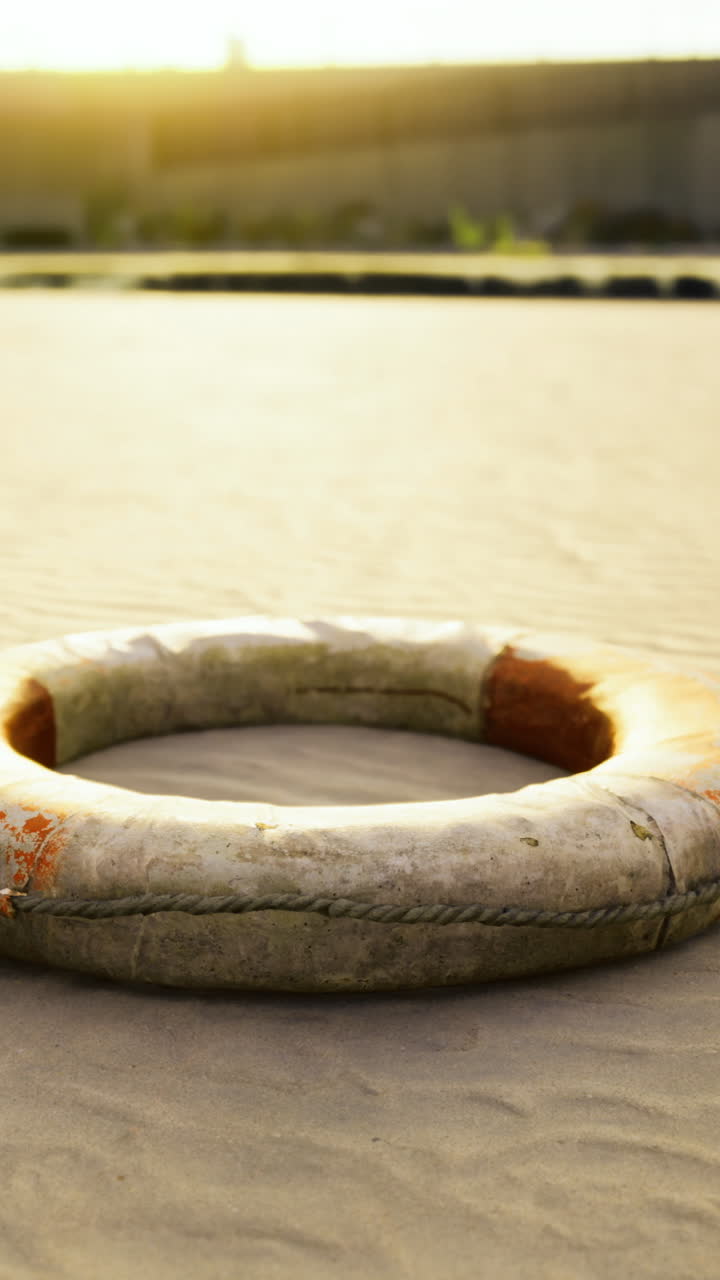 Lifebuoy nestled upon warm sands at sunset near quiet shoreline