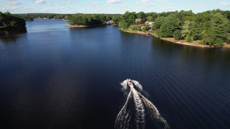 Drone flight descending towards a jetski speeding over the waters of Reynolds pond.