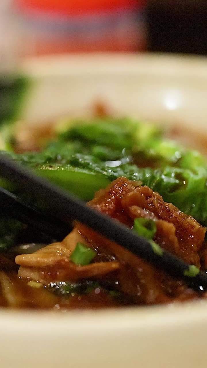 palillos para levantar la carne de la sopa de fideos