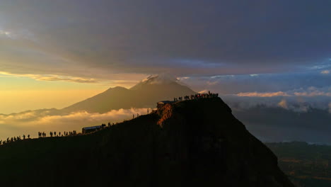 majestic aerial footage of mount batur in bali during sunrise. glowing volcanic peaks, morning mist, and golden skies create a stunning scene—ideal for nature, travel, and adventure content