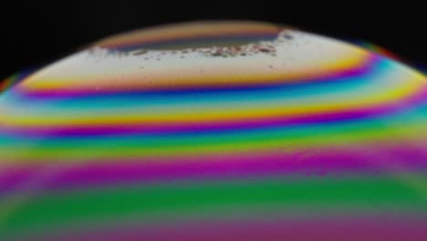 vivid rainbow colors swirl across a bubble's surface in a mesmerizing close-up shot