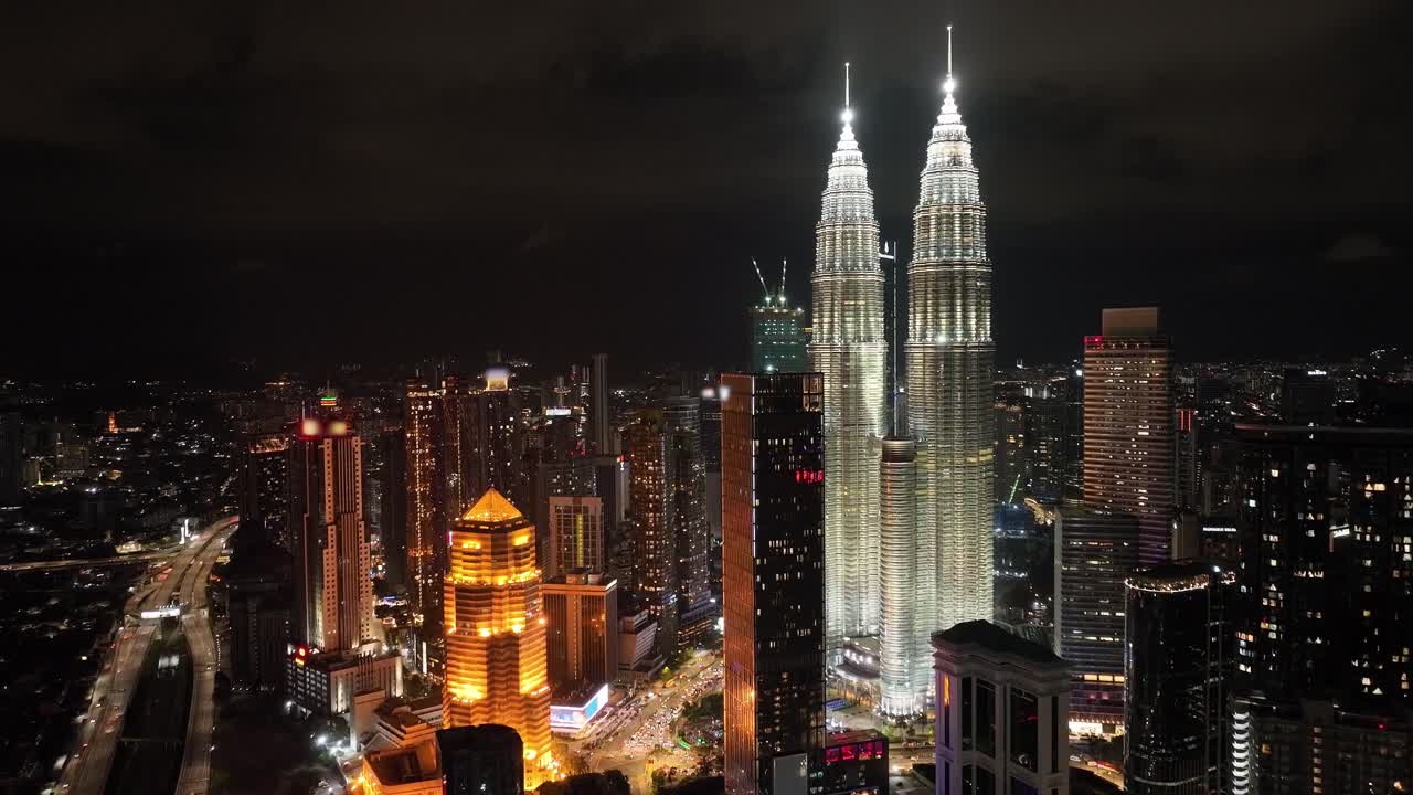 Toma de dron aérea nocturna con acercamiento de Kuala Lumpur y las Torres Petronas