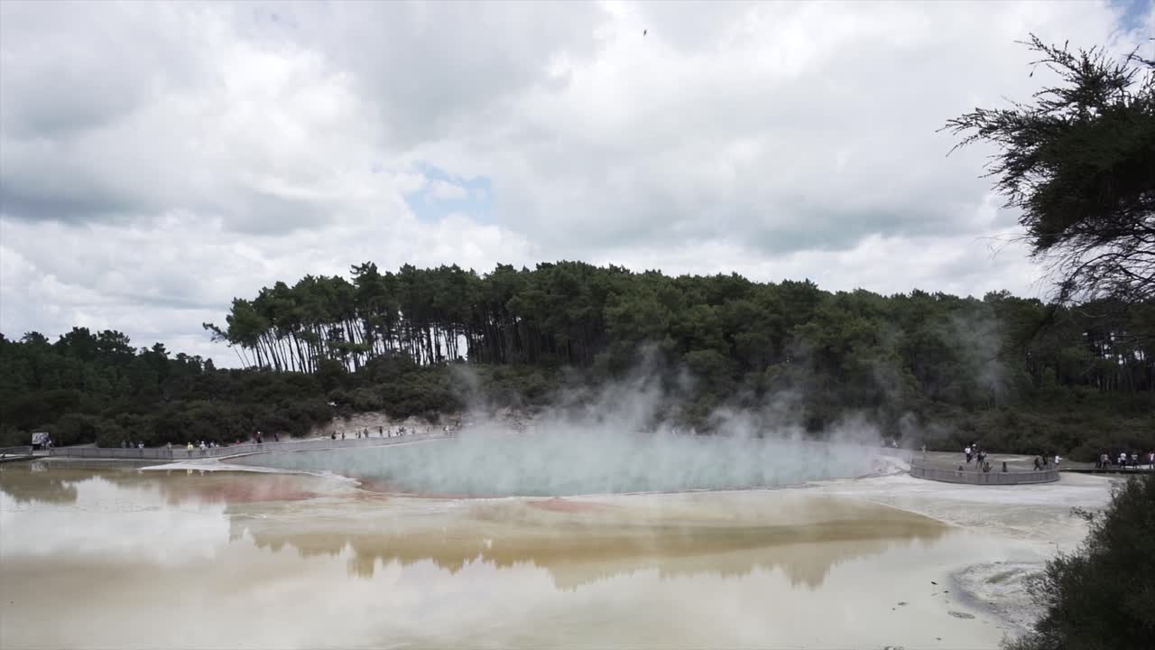Geothermal lake with steam and forest