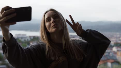 long haired woman takes a photo with a smartphone in her hands