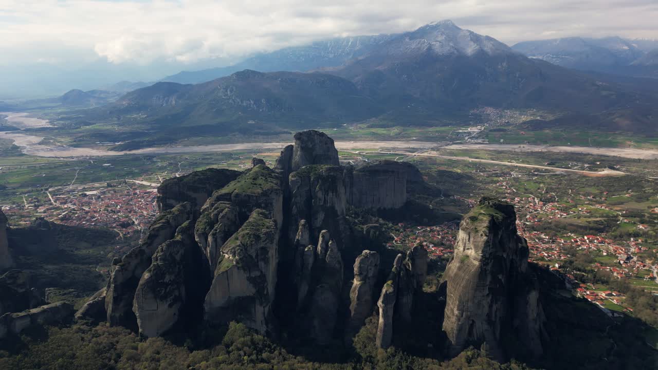 High altitude drone of Meteora rock pillars and monastery on cliff edge in Greece