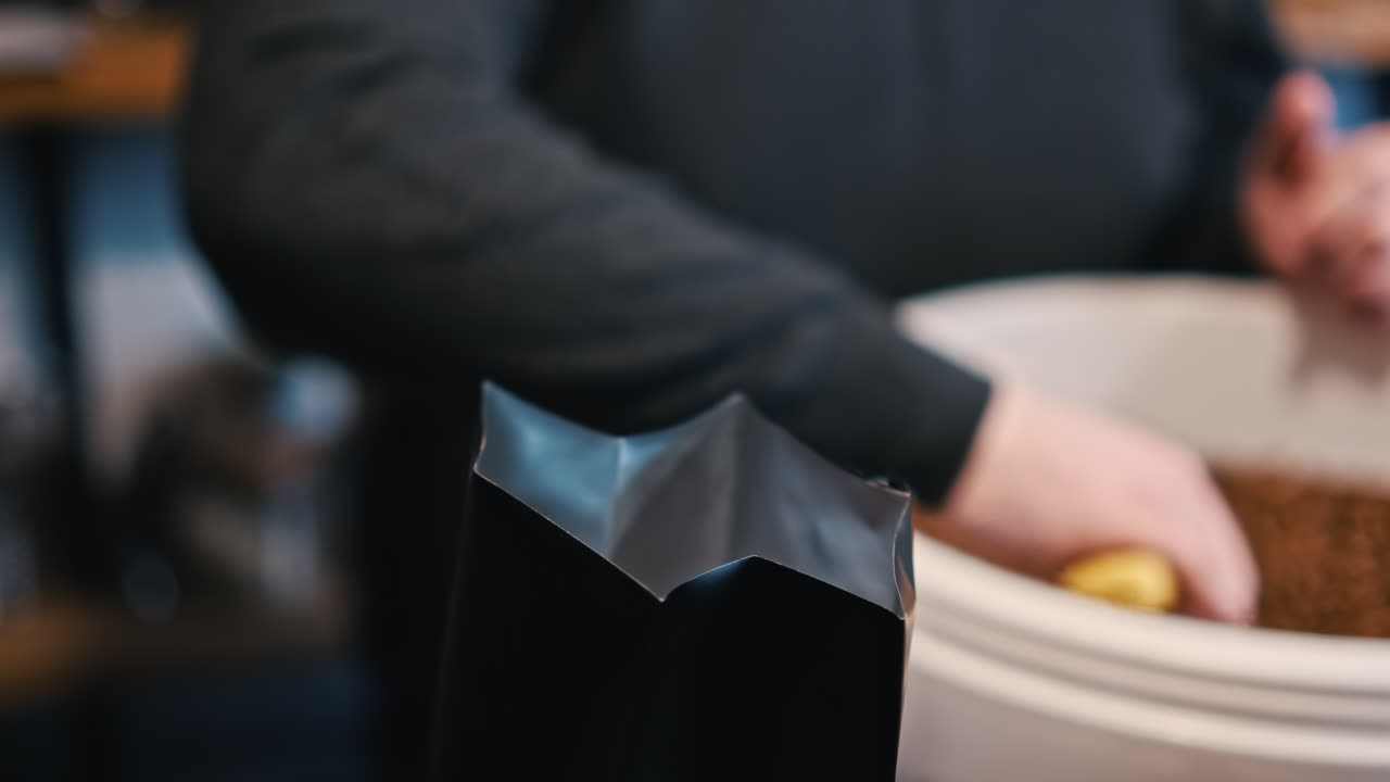 Un barista riempie un sacchetto di caffè in una caffetteria di Brasov, Romania