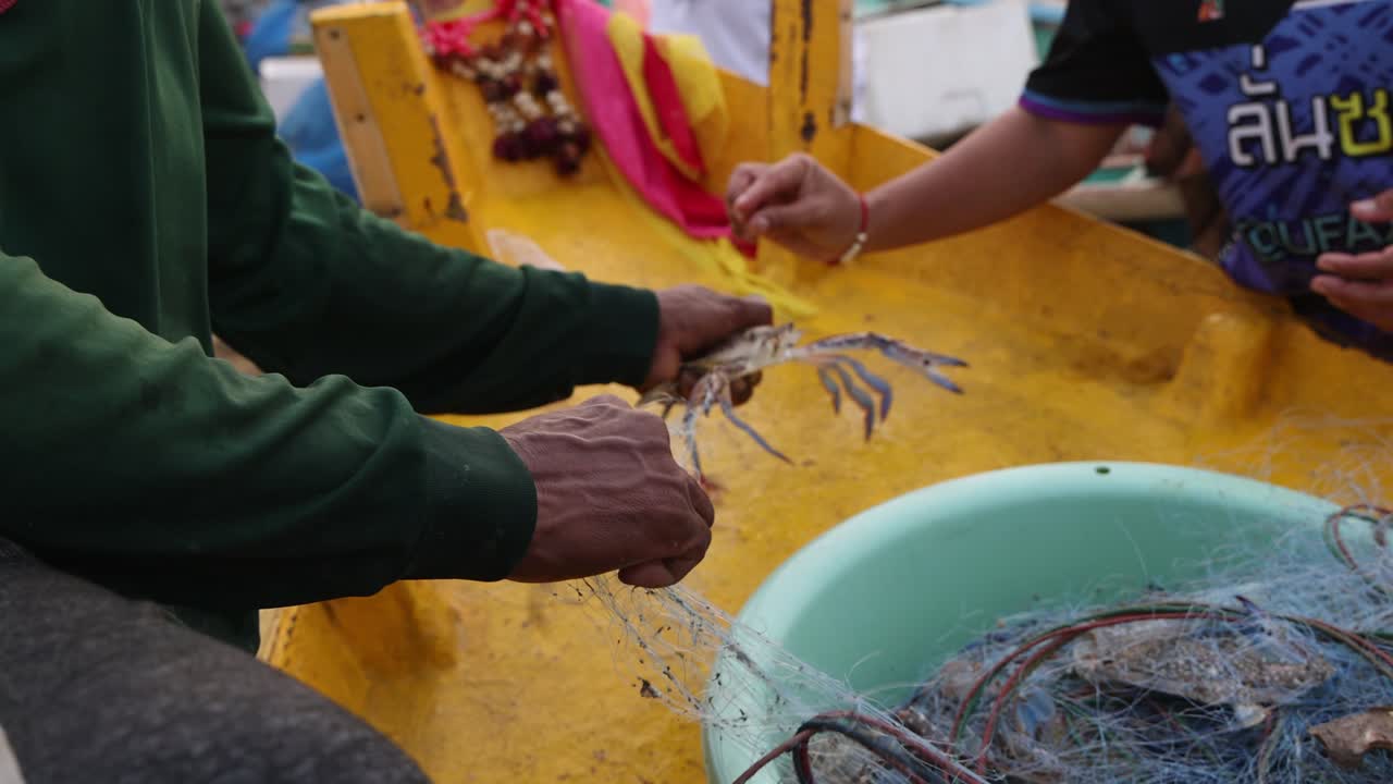 vista de cerca de un pescador que saca cangrejos de la red para venderlos en el mercado de mariscos de la playa en pattaya, jomtien, tailandia