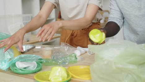 family couple sorting waste for recycling at home