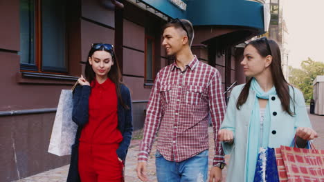 Steadicam-Shot-Friends---Two-Women-And-A-Man-Walking-Down-The-Street-With-Shopping-Bags