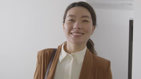 positive female candidate wearing suit leaving office after job interview