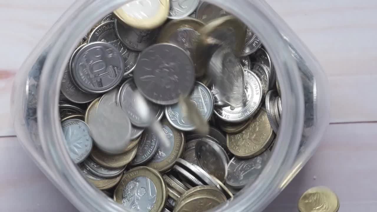 monedas llenando un frasco de vidrio