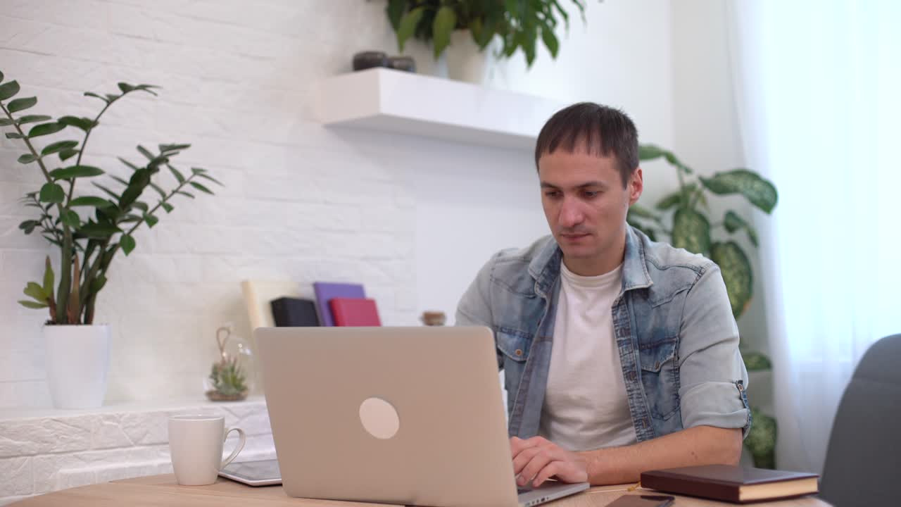 tiro en la cabeza tipo milenario sentado en la sala hace una videollamada mira a la cámara, conversación por videollamada a distancia, proceso de entrevista de trabajo de contratación a distancia, tutor y aprendiz estudio en línea