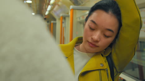 close up of young woman standing on underground train on journey to work or visiting city 1