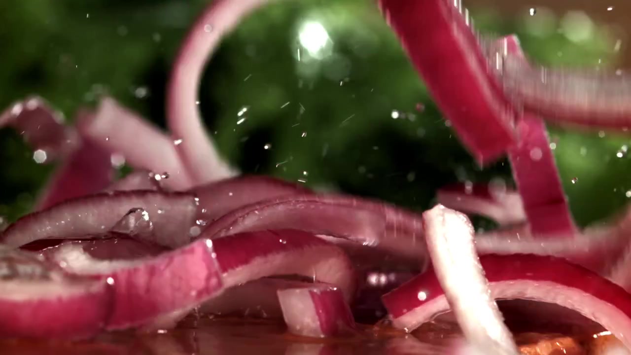 Fresh Red Onion Slices Falling and Splashing in Slow Motion
