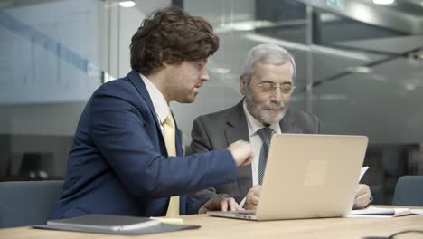 Young-manager-showing-financial-report-to-boss