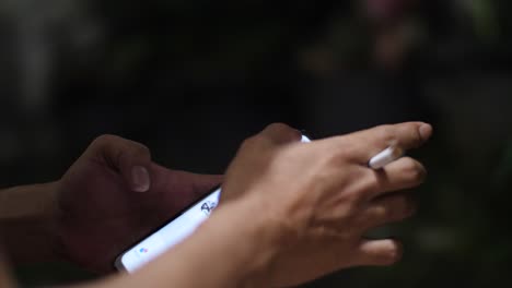 close up of hand with cigarette holding smartphon