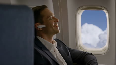 man relaxing on an airplane with earbuds