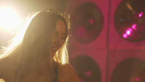 portrait of a happy young woman with headphones in multicolored lighting, slowmo