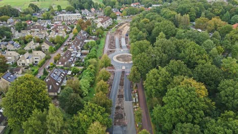 beautiful aerial of road under construction with a newly built roundabout in a rural town in the netherlands