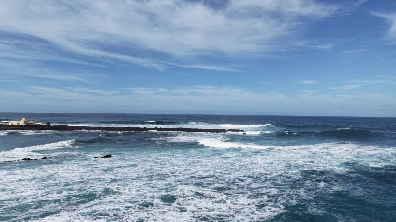 Onde che si infrangono sulla barriera frangiflutti a Tenerife, Spagna, ripresa aerea da drone.