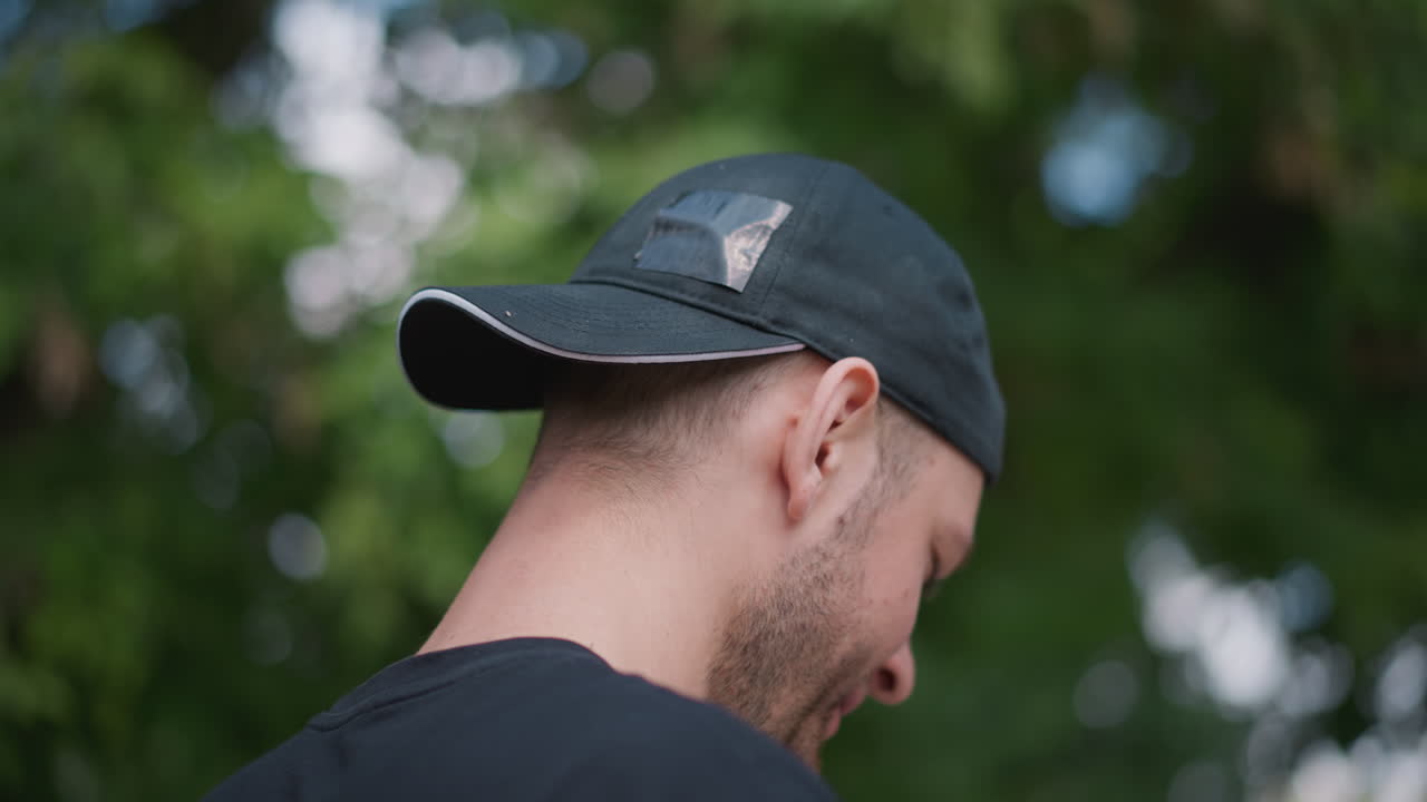 White Man Outdoors Drinking Water After Workout, Active Jogger Hydrating With Bottle, Cap Backward, Sweat And Relief, Park Foliage Bokeh, Refreshing Sip, Wellness Routine, Candid Fitness Moment