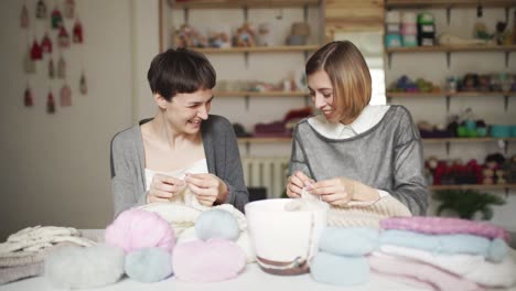 Zwei-Glückliche-Freundinnen-Haben-Spaß-Daran,-Wollkleidung-Im-Heimstudio-Zu-Stricken