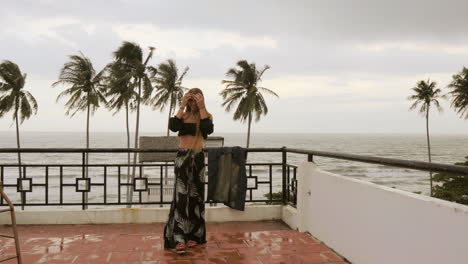 long haired blonde russian model posing in front of the camera while on a rooftop along the ocean in vietnam