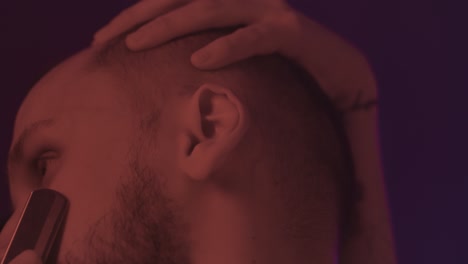 close-up of a man getting his beard trimmed