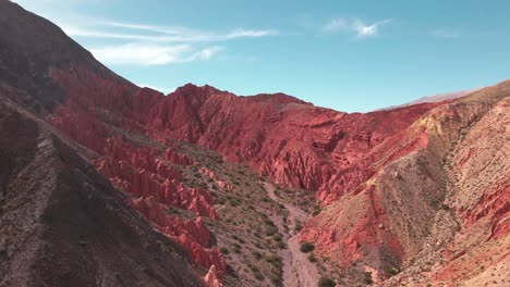 Luftaufnahme-Des-Roten-Tals-Von-Los-Colorados,-Purmamarca,-Jujuy,-Blauer-Himmel,-Nordargentinien