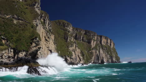 dramatic sea cliffs and crashing waves on a clear day