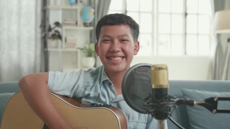 happy teenager playing acoustic guitar