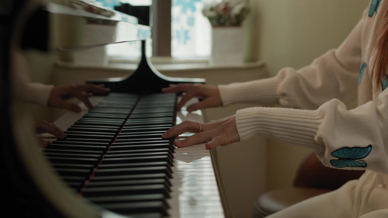 Donna che suona il pianoforte a casa in un ambiente accogliente e caldo. Carrellata all'indietro. Rallentatore.