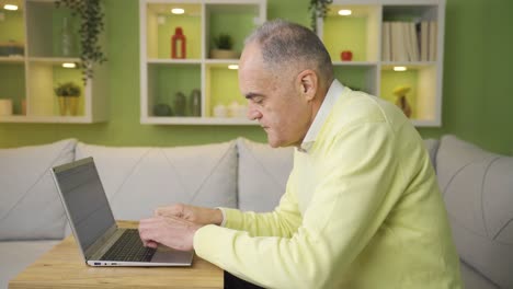 Thoughtful and bored old man working on laptop, feeling depressed.