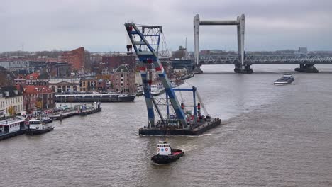 riverside charm of city provides backdrop as formidable crane and boat pass