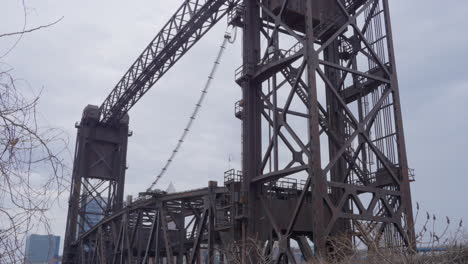 tilt-up-shot-of-historic-vertical-lift-bridge-in-Cleveland-Flats-on-Cuyahoga-river-on-a-cloudy-day