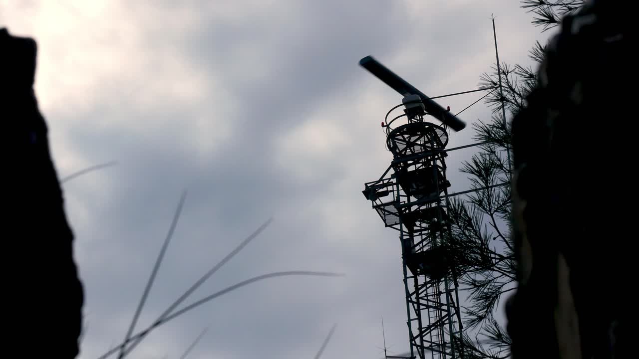 torre de radar con antena giratoria en un fondo nublado