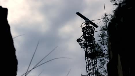 radar tower with rotating antenna in cloudy background