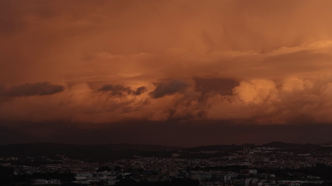 Drone shot amazing storm clouds over city with sunset colors