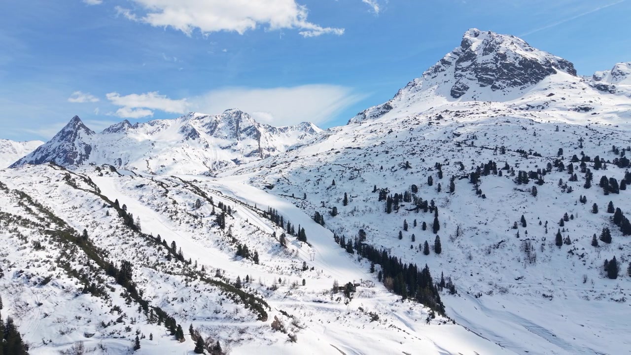 Paesaggio montano innevato presso la stazione sciistica Silvapark a Galtür, Austria. Ripresa con drone in allontanamento.