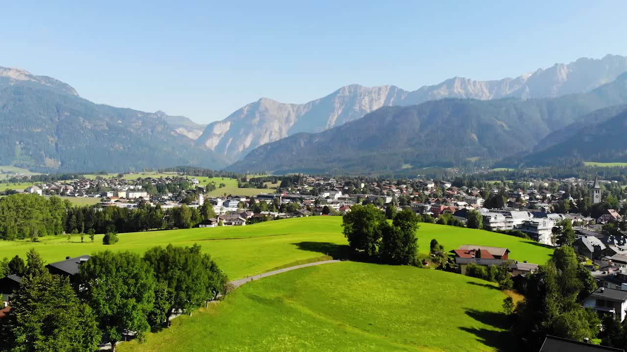 Saalfelden, Austria. The summer months in small town in Austria that showcases surrounding mountain views and beautiful green pastures that are incorporated into the small Austrian town. 60 fps.