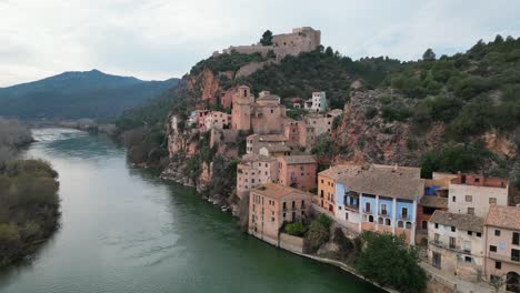 Miravet,-Un-Pintoresco-Pueblo-De-Tarragona,-España,-Junto-A-Un-Río-Sereno,-Vista-Aérea