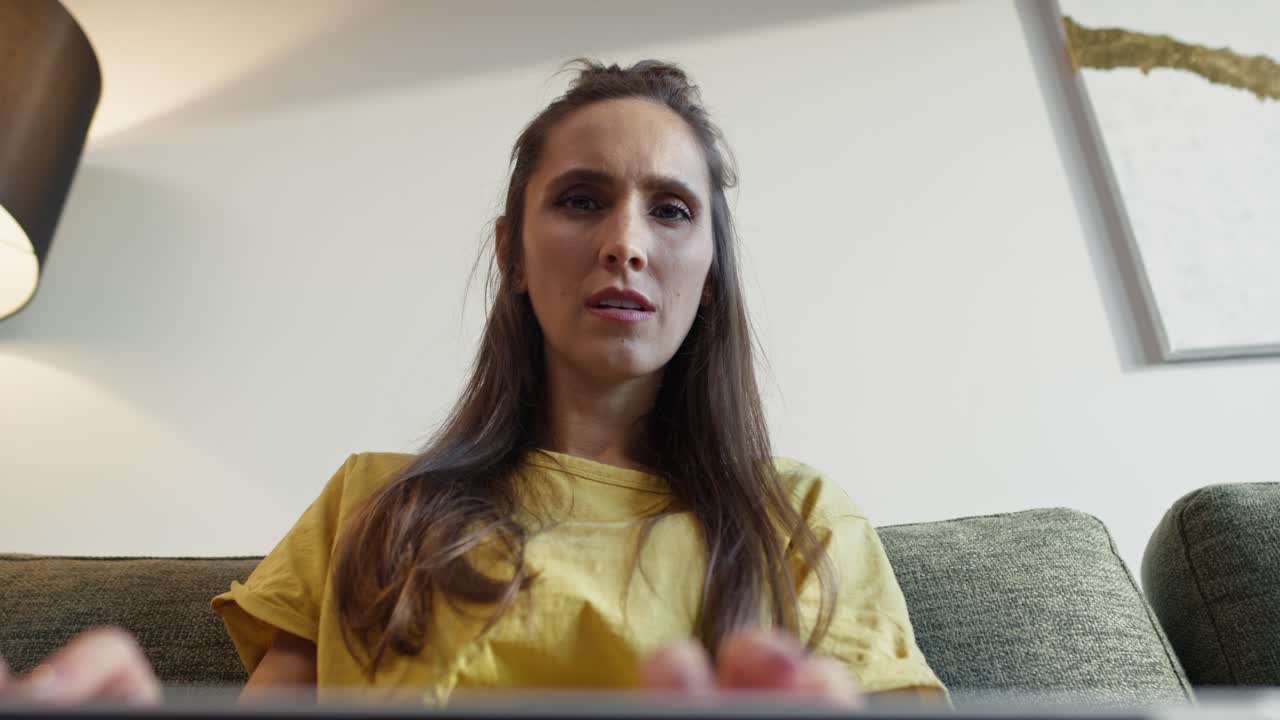 Punto di vista dal portatile di una donna caucasica che digita ed è concentrata