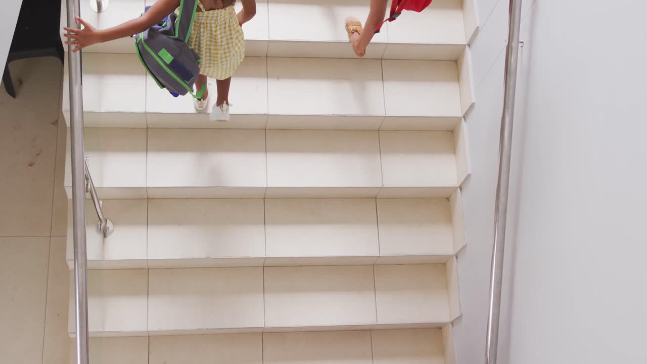 Video af mangfoldige piger, der går op ad trappen i skolen, set oppefra.