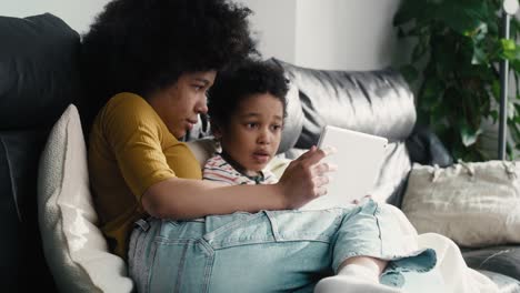 Wide-shot-of-two-children-browsing-digital-tablet-in-the-living-room