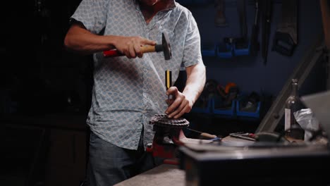 toma cinematográfica de un mecánico rompiendo una cadena con un destornillador
